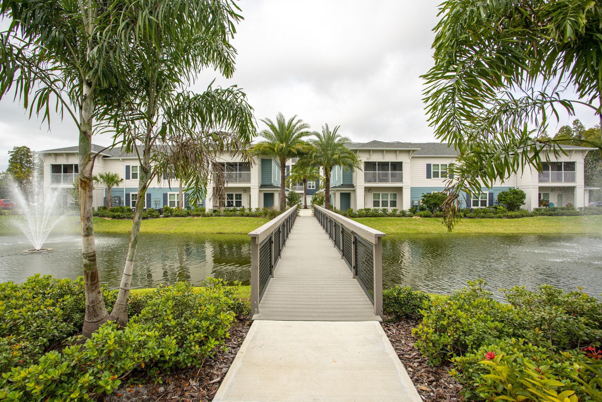 Bridge over a small pond leading to residential buildings